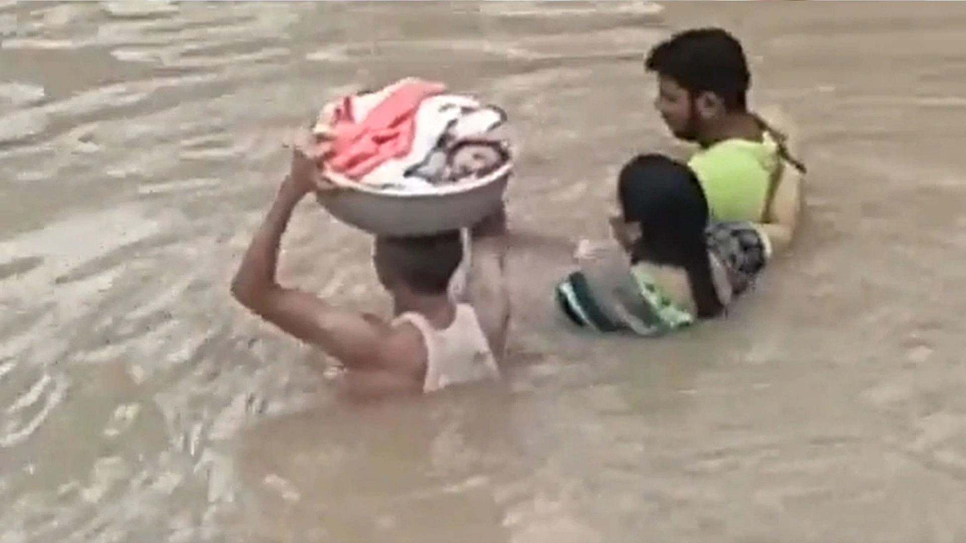 Man crossed the path full of water with the kid on his head watch viral video of telangana flood
