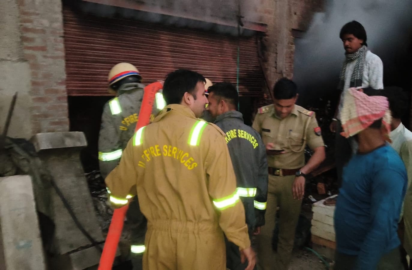नगला बरी स्थित स्क्रैब गोदाम में आग बुझाते फायर कर्मी, साथ में मौजूद एफएसओ दुर्गेश कुमार त्याग