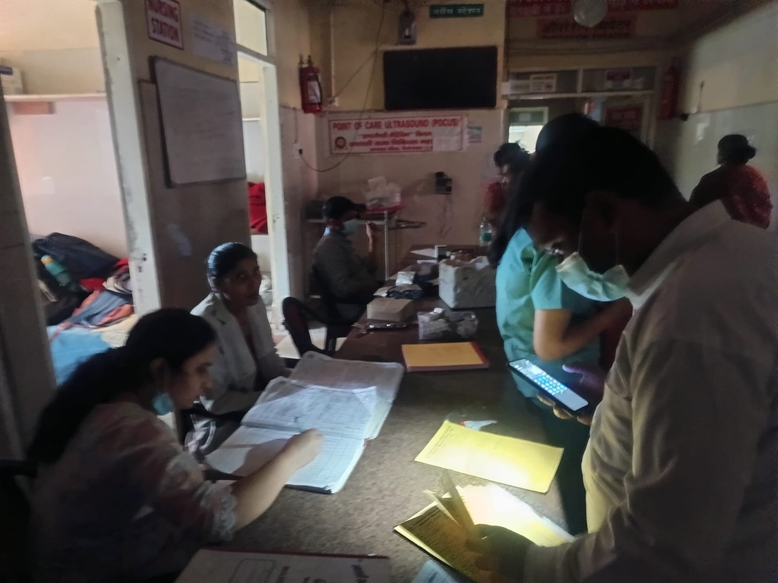 ट्रामा सेंटर में मोबाइल की रोशनी से वार्ड में मरीजों के शिफ्ट होने की फाइल देखते स्वास्थ्य कर्