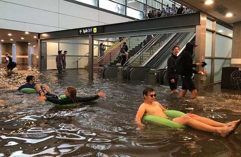 Sweden: Rain water stuck in railway platform, people doing their fun activity 
