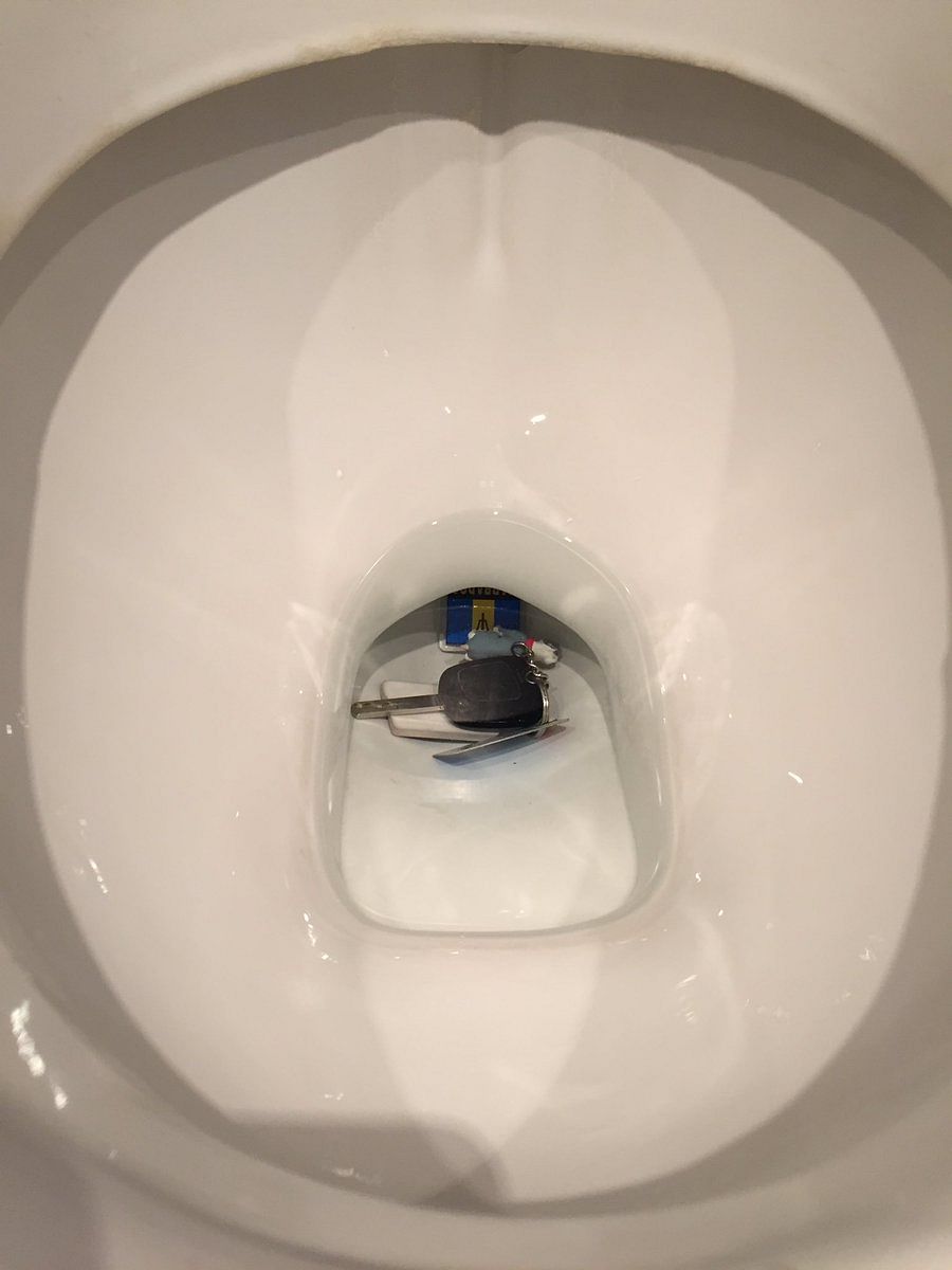 man hand stuck hand in toilet while trying to find car keys