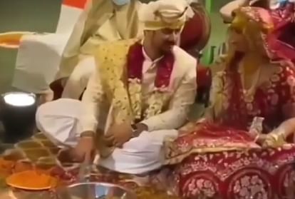 दूल्हा दुल्हन शादी के दौरान बोतल फ्लिप गेम खेल रहे हैं