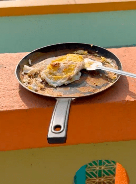 Man made omelette without a stove cooked egg in the sun on the terrace