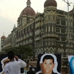 ताज होटल के बाहर मुंबई आतंकी हमले के शहीदों के चित्र बनाते लोग