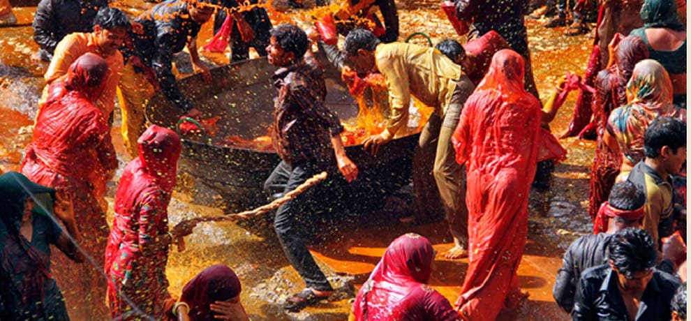 women play holi with colours and beat men with swinge