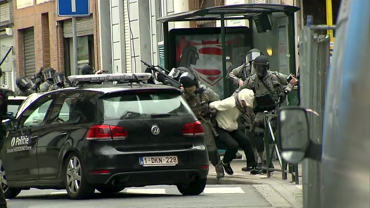Armed Belgian police apprehend a suspect salah abdeslam, in Molenbeek, near Brussels