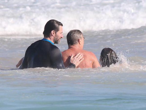 Actor Hugh Jackman helps swimmers to safety from dangerous surf