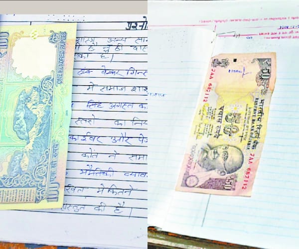 Money in students examination note book.