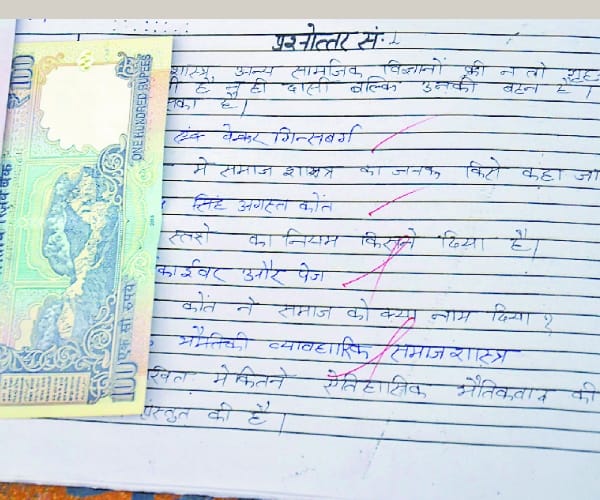 Money in students examination note book.