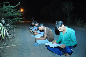 polytecnic student reading in streat light