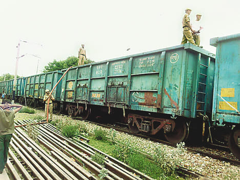 Smoke-laden goods train carrying coal coach