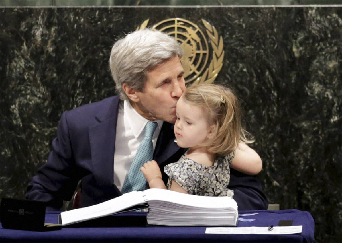 John Kerry kisses his granddaughter after signing the Paris Agreement