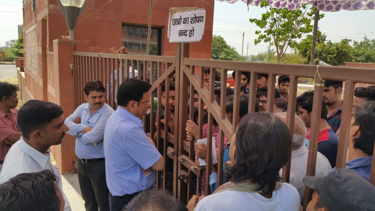 State University students on strike again , hanging on the gate lock