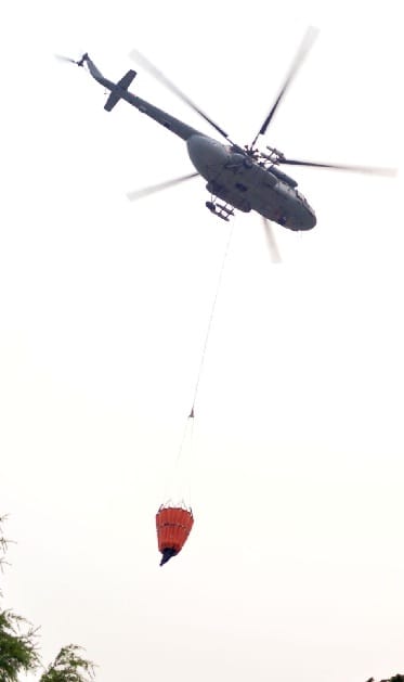 helicopter takes water from the Bhimtal