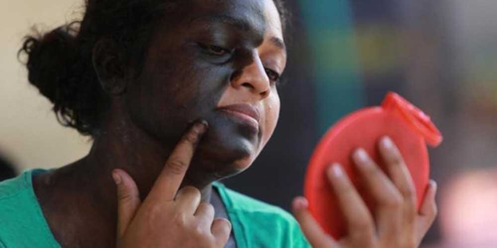 Kerela based woman applies black paint on face