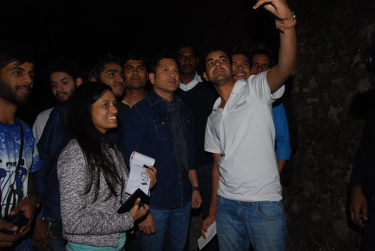 sachin tendulkar poses with his fans.