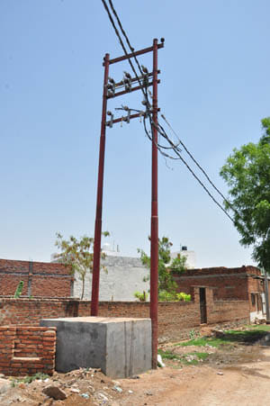 Heap of dirt , wooden electric wires on poles