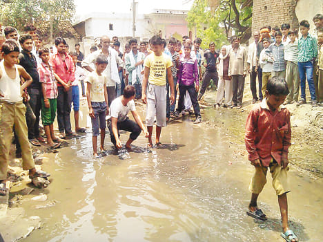 villagers stood in water logging road