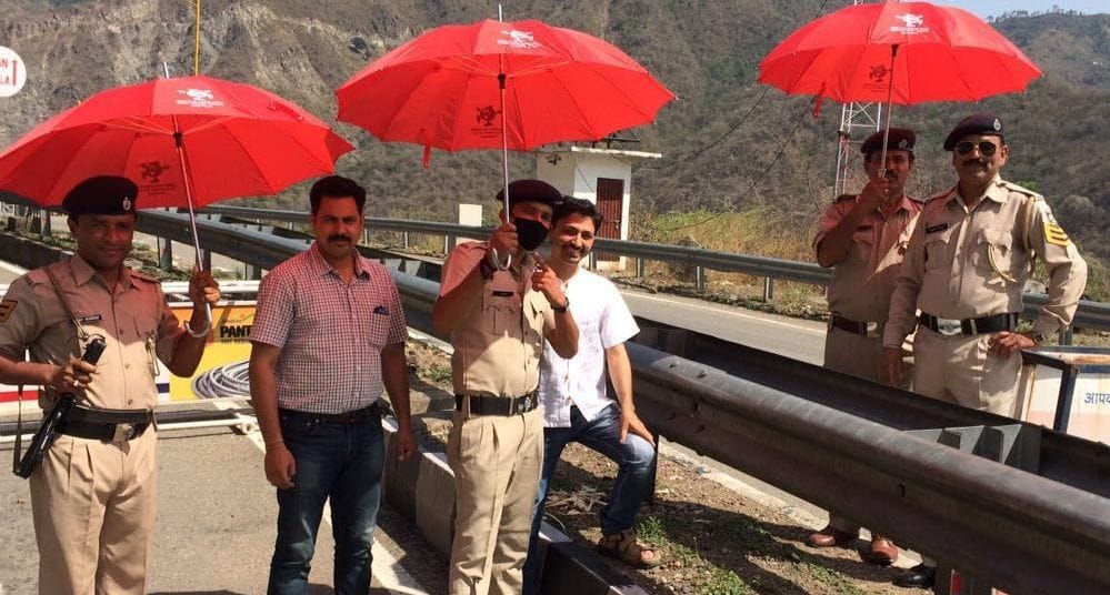 police doing his duty under red umbrella