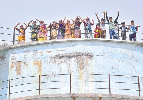 woman climb on water tank for water