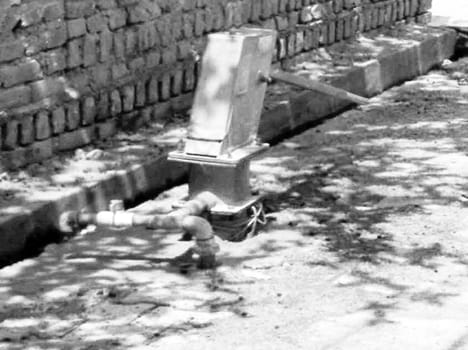 Hand pumps vulnerable to government encroachment on the outside of homes