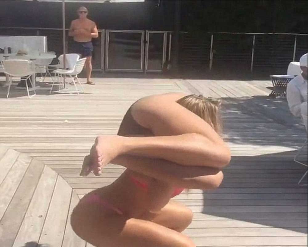 bikini girl performing squats with her friend