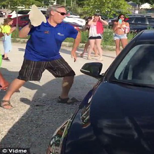 Passer-by uses a rock to smash car window and free a dog locked inside during extreme heat  