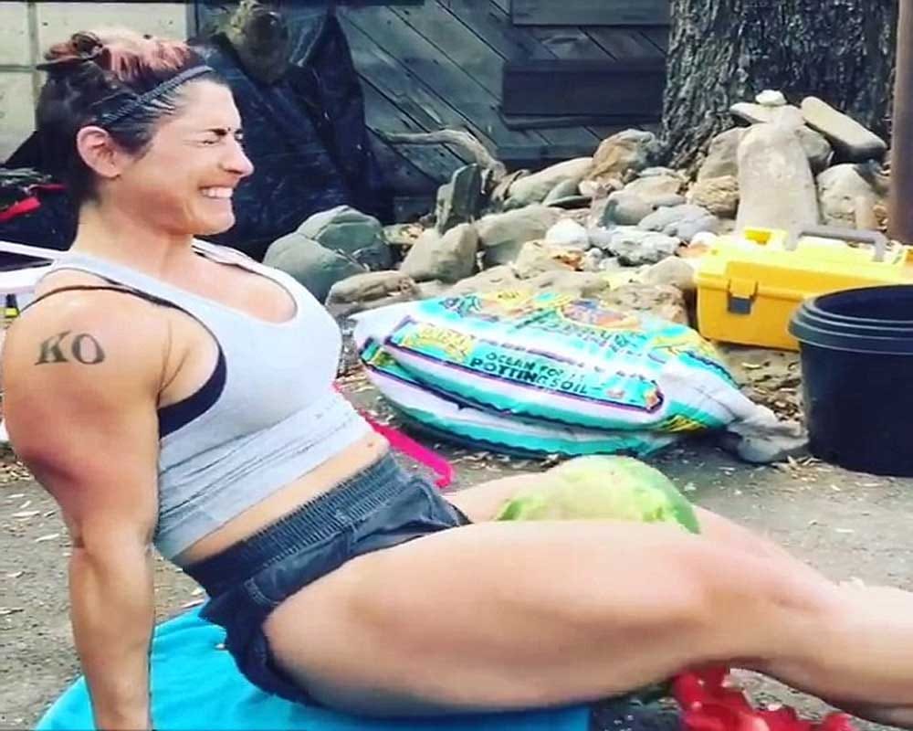 Woman crushing watermelon with her thighs