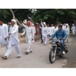 नारेबाजी करते हुए धरना स्थल पर पहुंचते समुदाय के लोग।