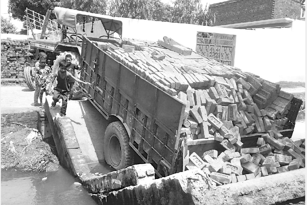 Brick-laden tractor trolley embedded in culvert 