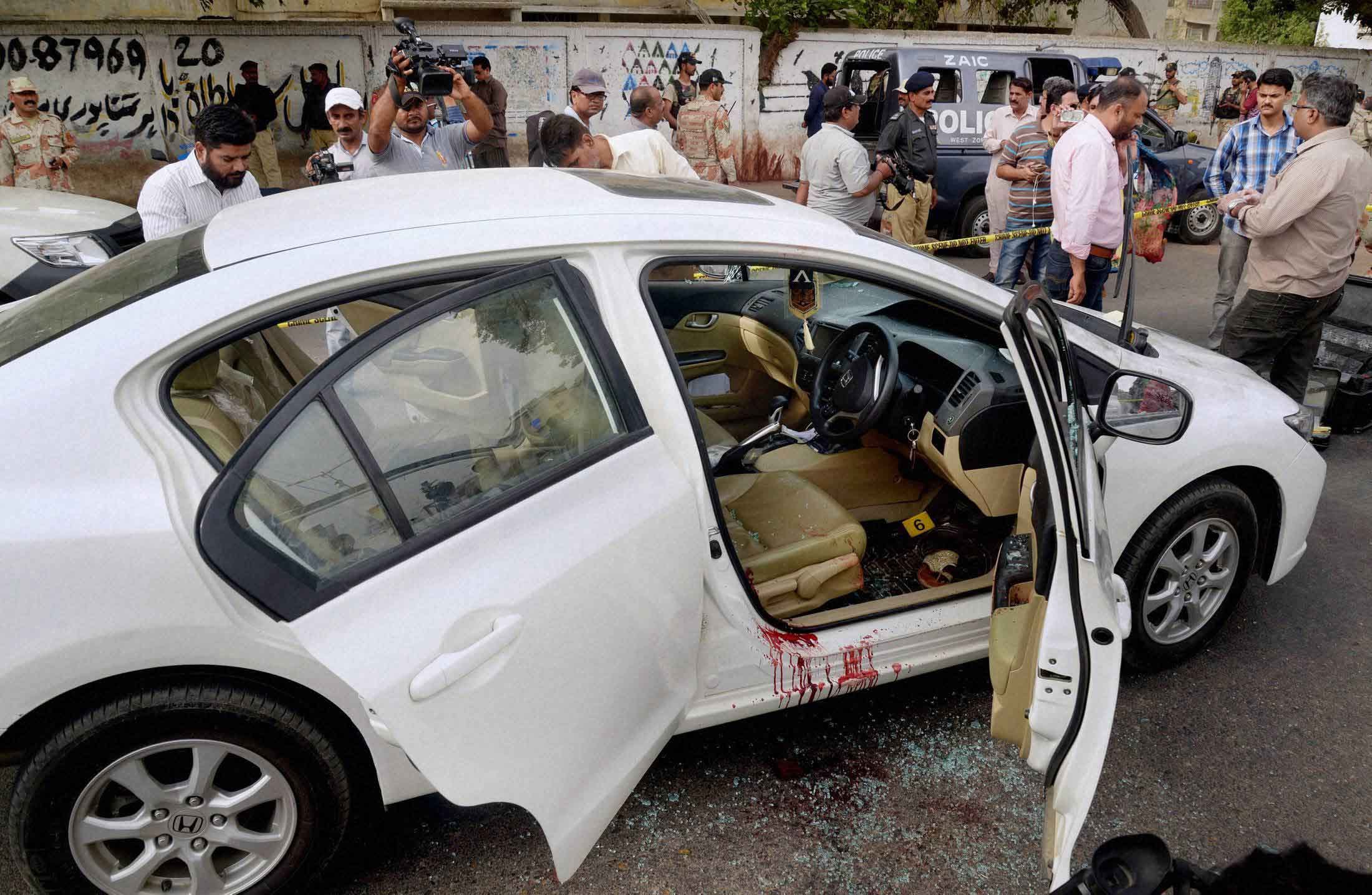 People throw flower petals on the ambulance carrying the body of Amjad Sabri
