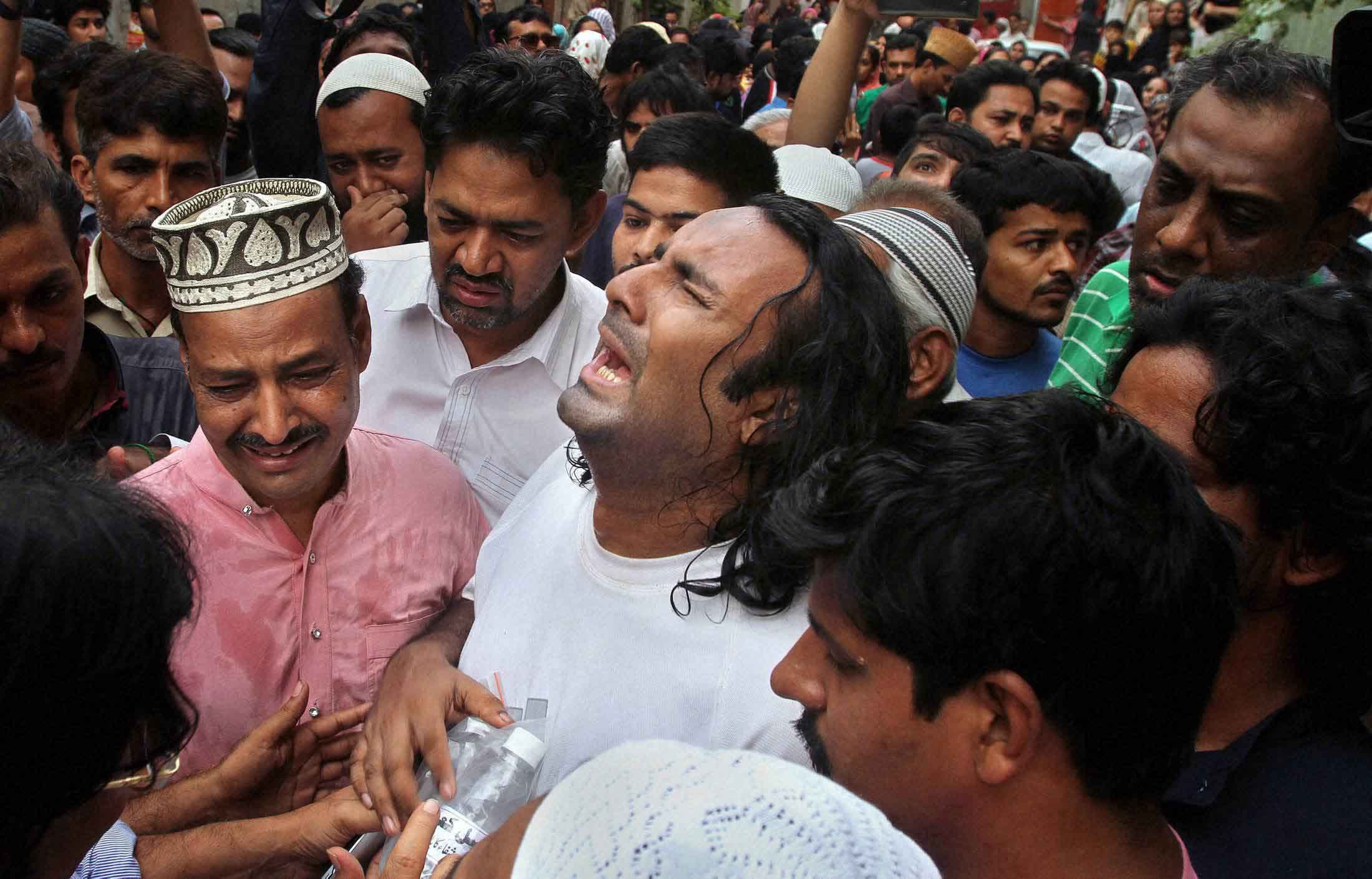 People throw flower petals on the ambulance carrying the body of Amjad Sabri