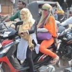  बिना हेल्मेट लगाए मोटरसाइकिल चलाते लोग।