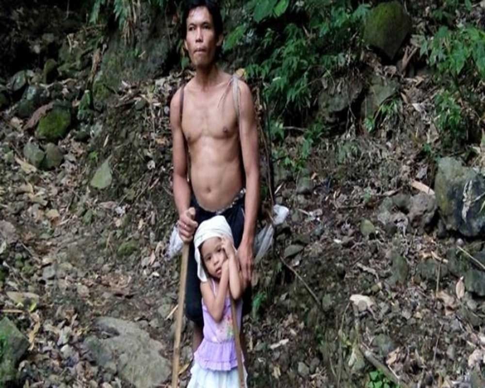 five-year-old girl guiding her blind father to work with a stick 