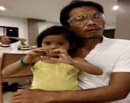 five-year-old girl guiding her blind father to work with a stick 
