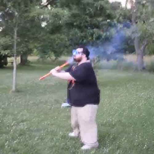 Idiot lights firework under his chin 