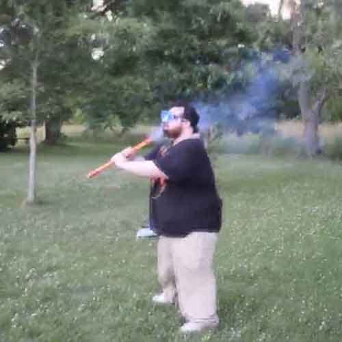 Idiot lights firework under his chin 
