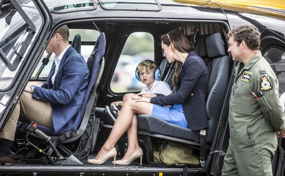 Prince George looks up at the tail rotor of a "Squirrel" helicopter 