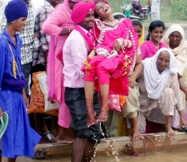 amazing love, groom lift up bride in arms to cross the beas river in jalandhar of punjab