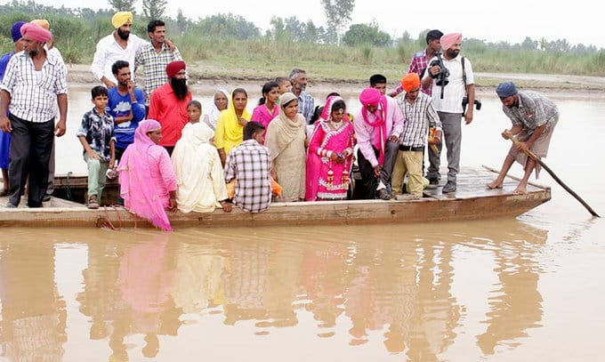 amazing love, groom lift up bride in arms to cross the beas river in jalandhar of punjab
