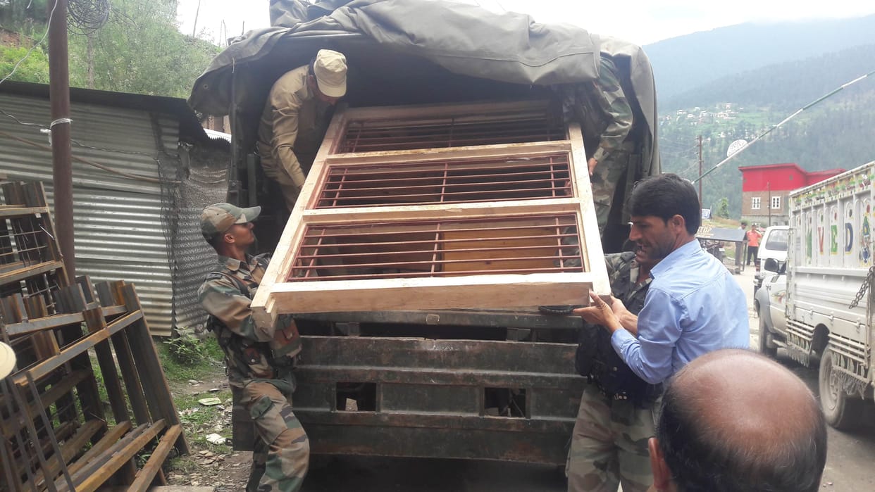 Two army trucks being brought illegally seized timber