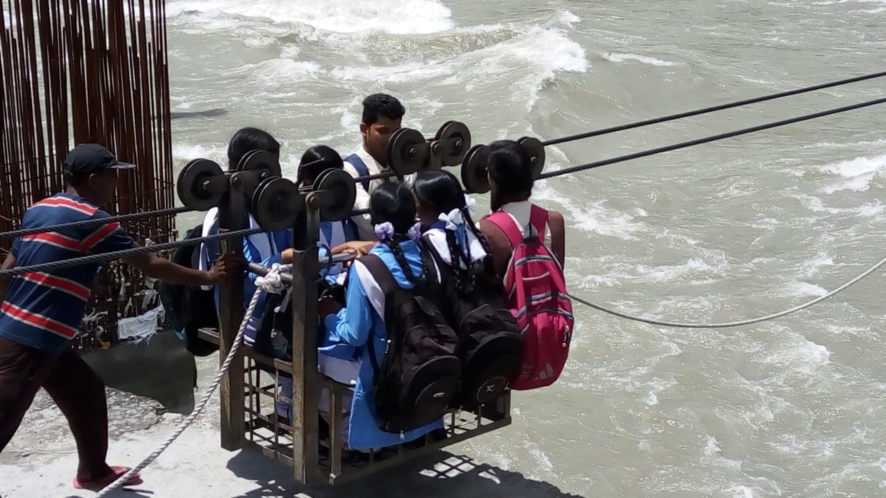 student crossing river by trolley.