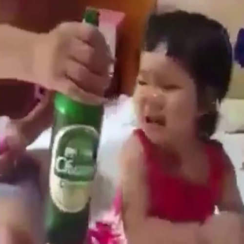 father feeding beer to baby