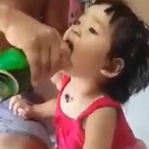 father feeding beer to baby