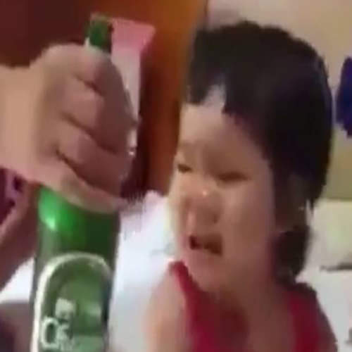 father feeding beer to baby