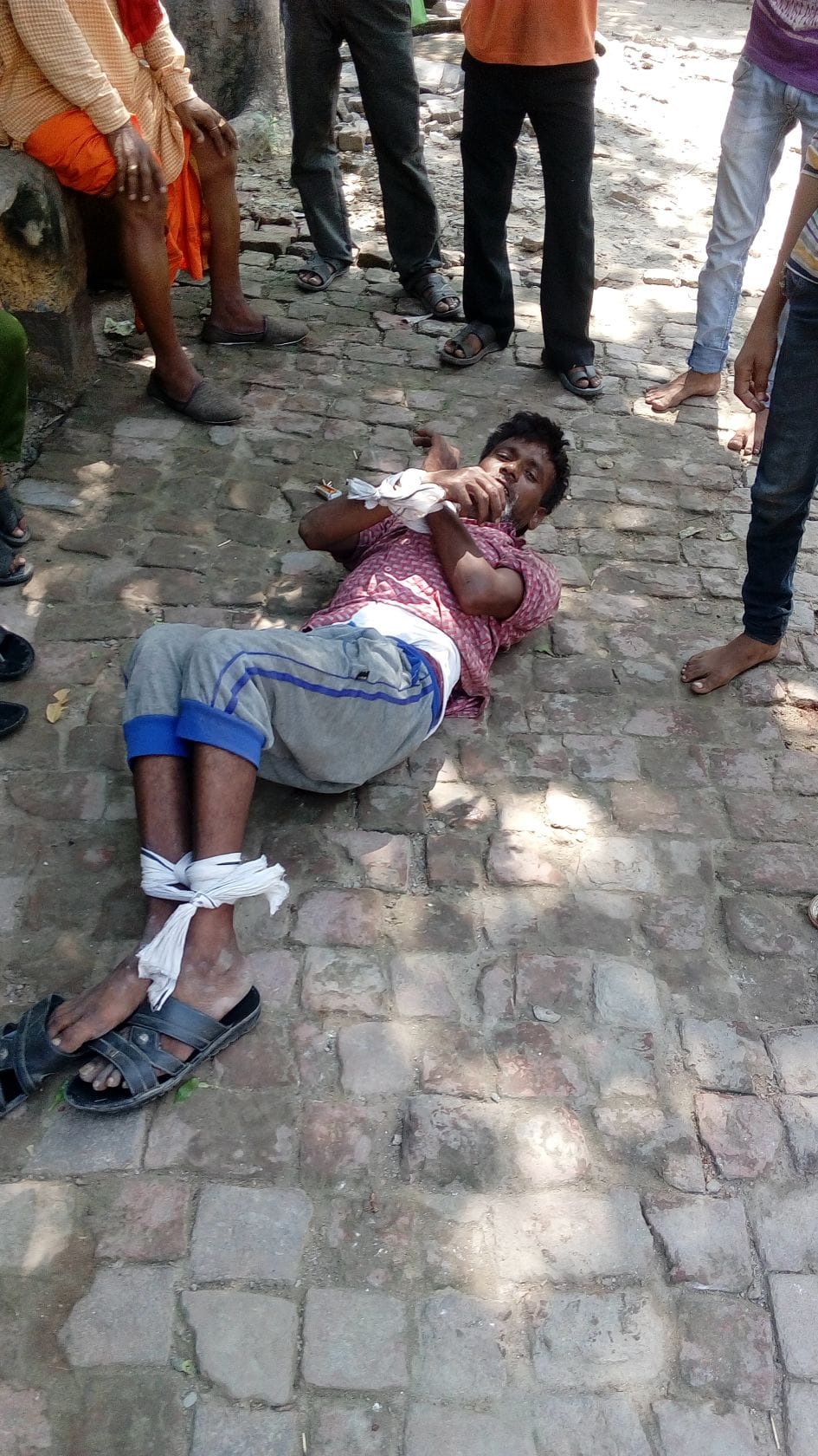 Shackled hand and foot in front of the police beating a thief