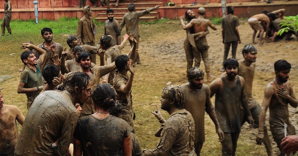 boys girls students of central university playing in mud for janamashtmi celebration