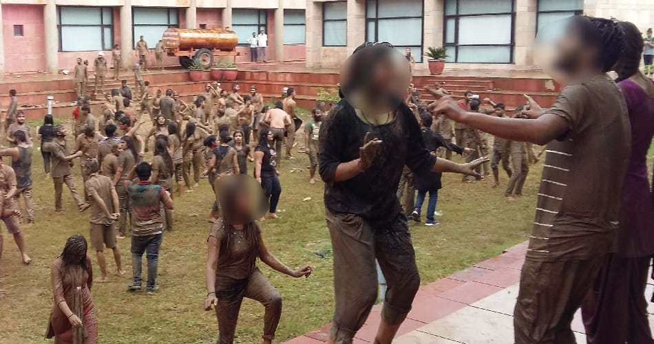 boys girls students of central university playing in mud for janamashtmi celebration
