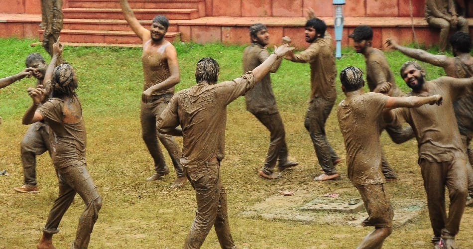 boys girls students of central university playing in mud for janamashtmi celebration