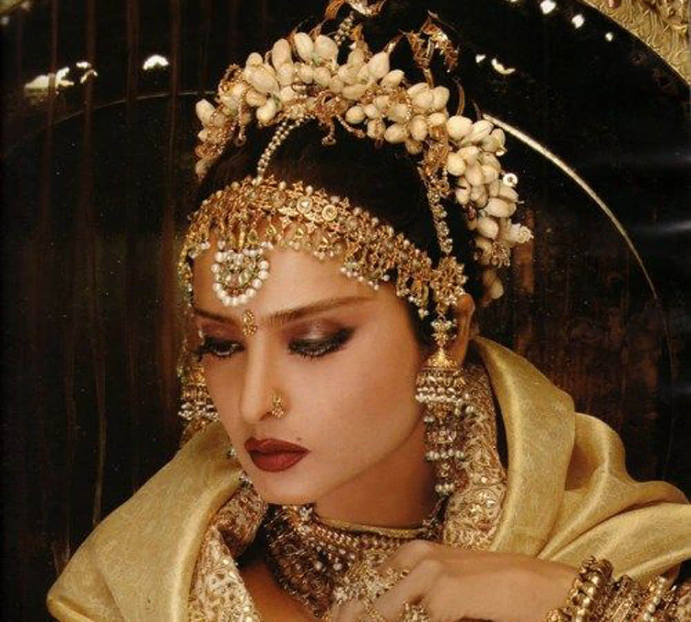 rekha spoted doing something inside her car